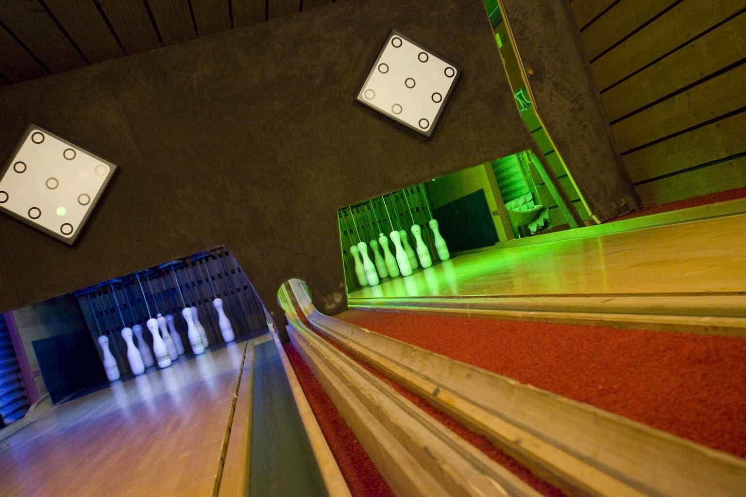 A bowling alley with lanes, pins, and illuminated targets.