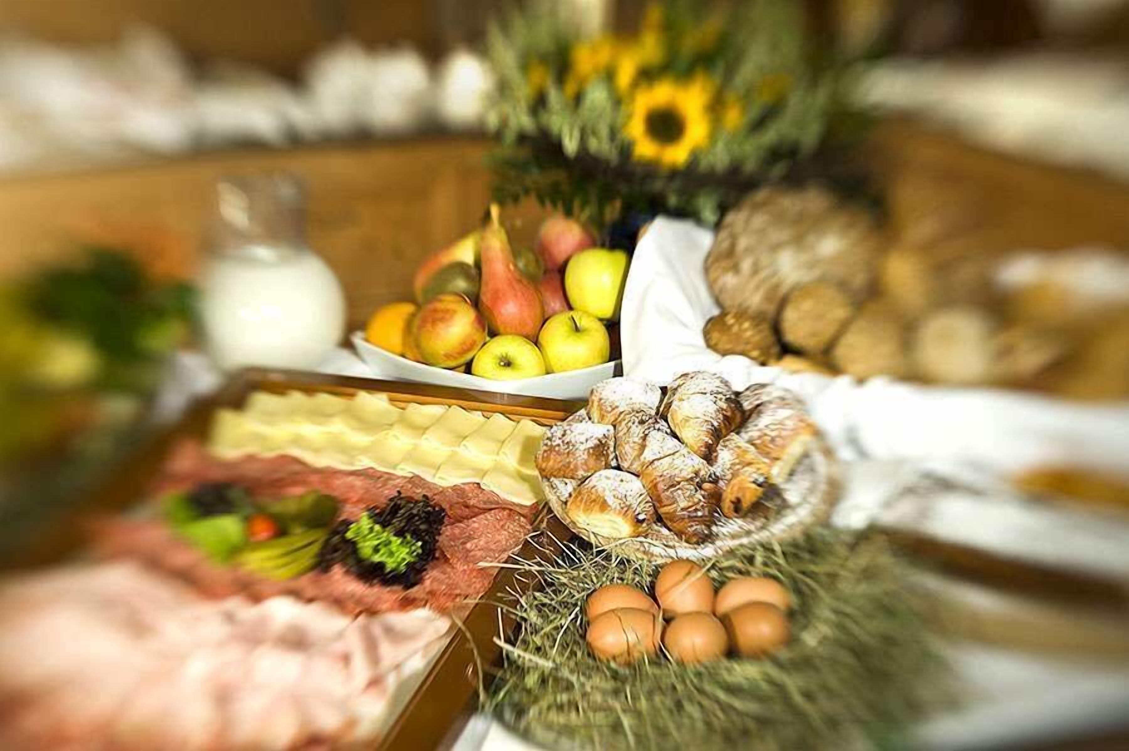 A table with various food items including fruits, bread, and eggs.