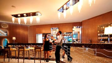 A bar area with a counter, bar stools, and a bartender.