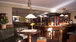 A bar area with wooden furniture, a bar counter, and hanging lamps. - Hotel Englischer Hof (Herzberg am Harz)