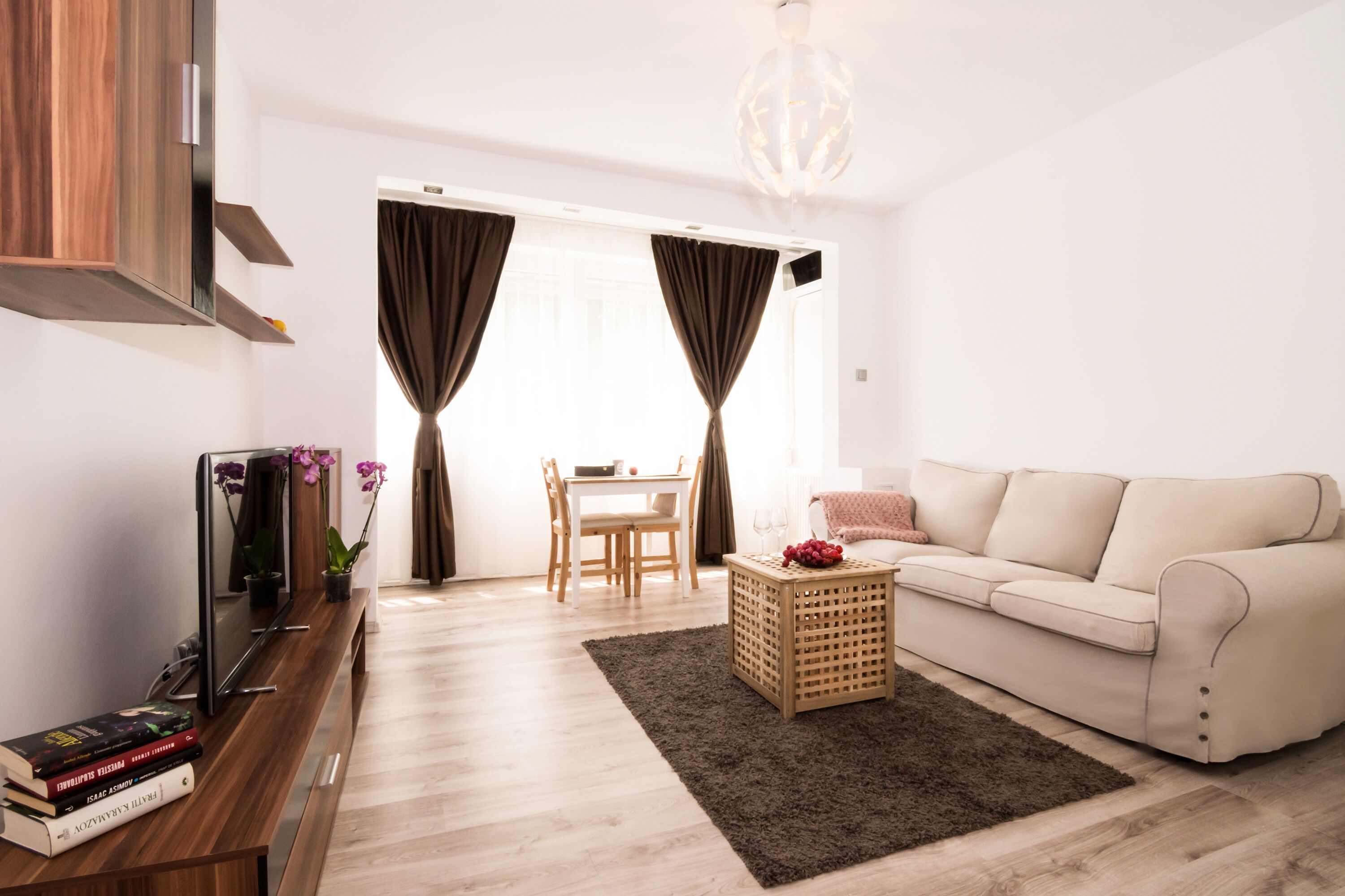 Un salon moderne comprenant un canapé, une table basse, un téléviseur et un coin repas avec une table et des chaises.