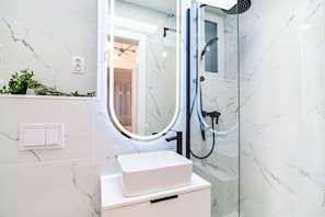 Luxury Apartment | Bathroom | Shower, rainfall showerhead, hair dryer, towels