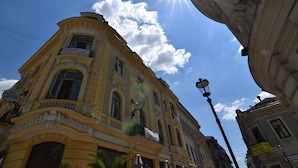 A historic building with ornate architecture, large windows, and a balcony.