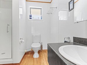 Een moderne badkamer met douche, toilet en bad.