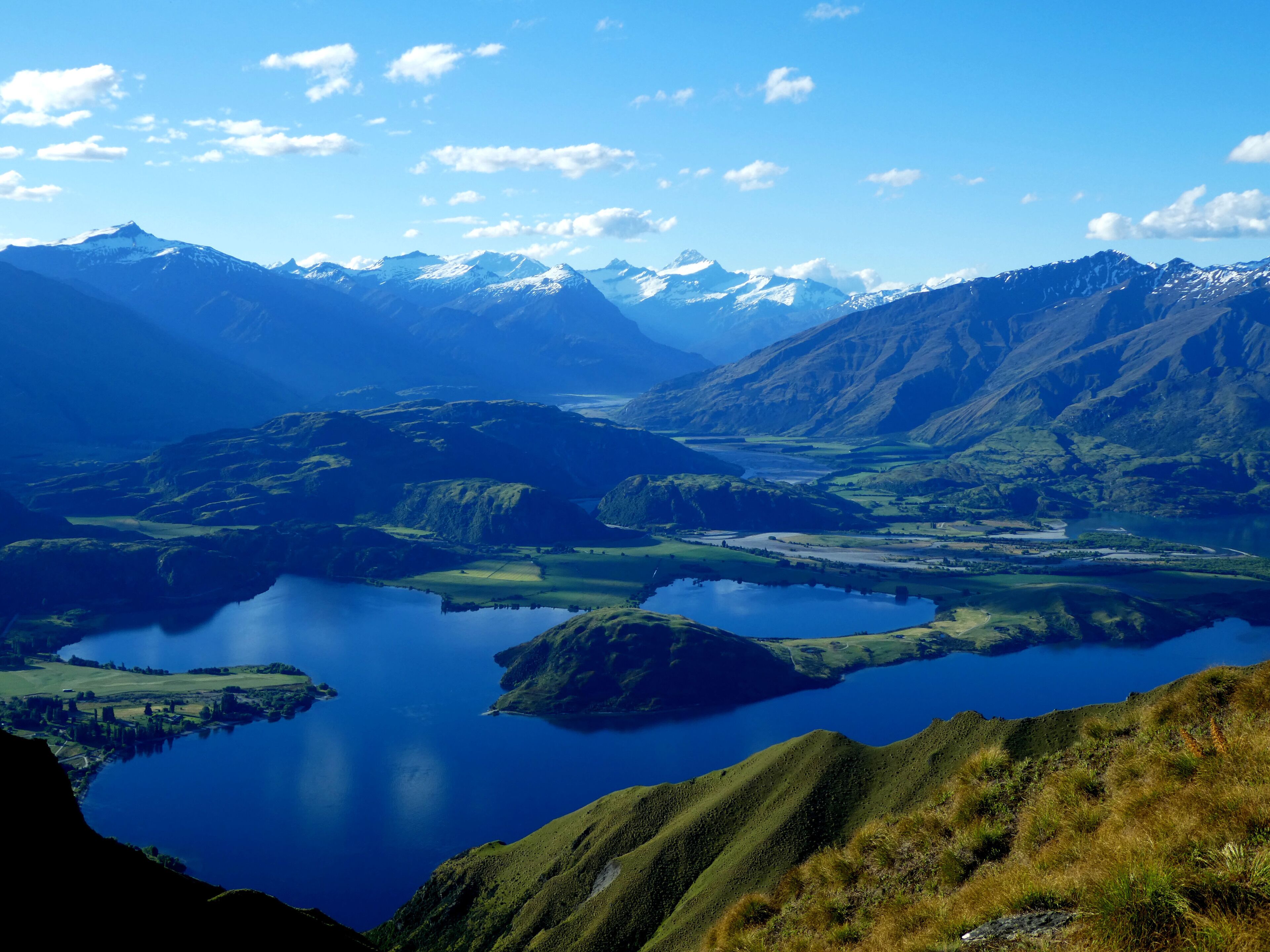 Un paisaje montañoso con un gran lago rodeado de colinas y montañas.