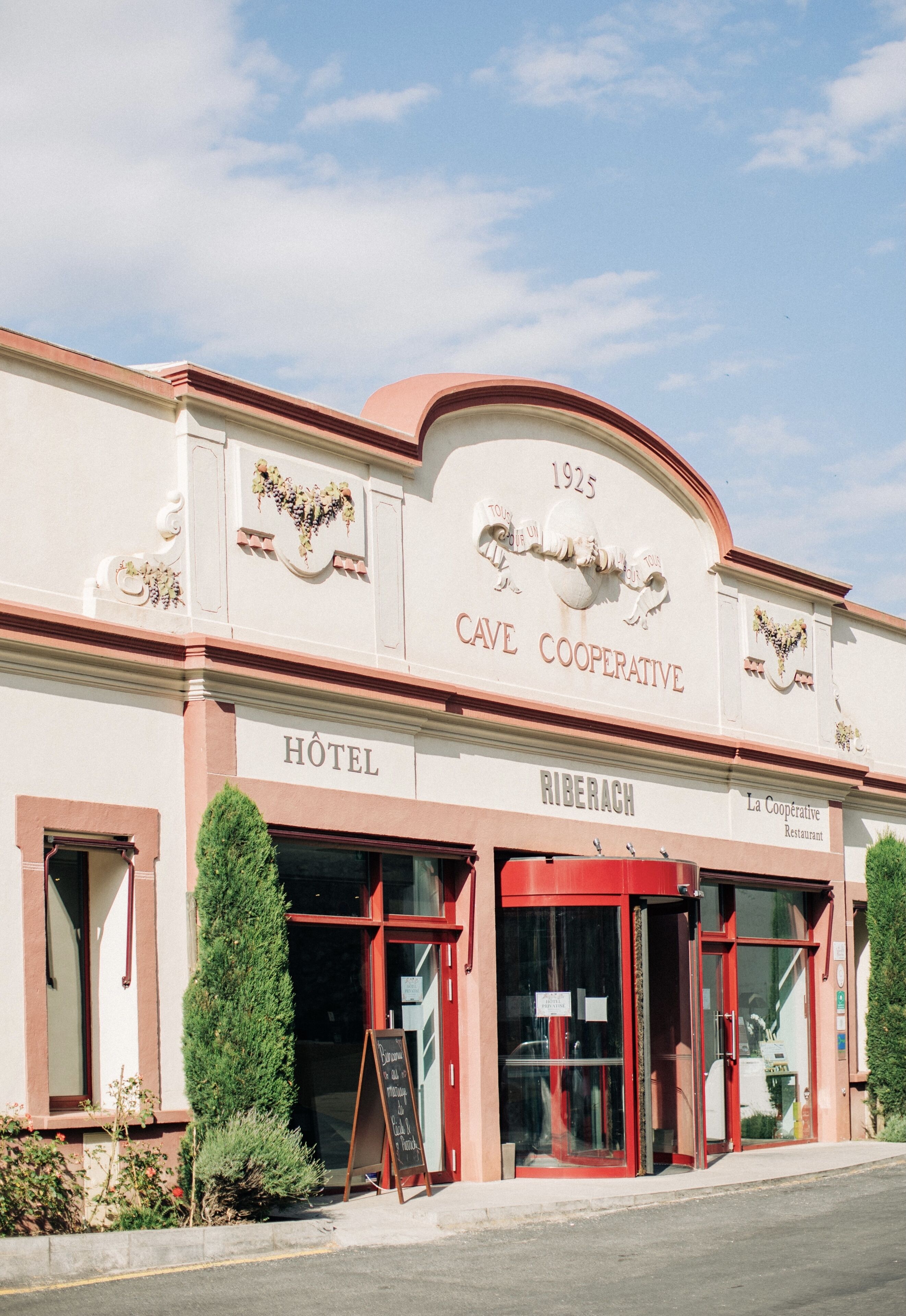 A historic building with a sign reading "CAVE COOPERATIVE HOTEL" and "RIBERACH."