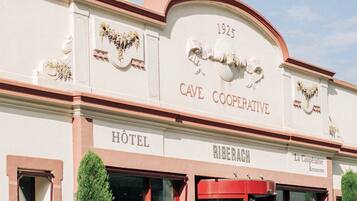 A historic building with a sign reading "CAVE COOPERATIVE HOTEL" and "RIBERACH."