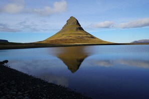 Un lago tranquilo con una montaña al fondo.
