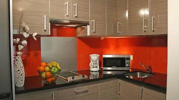 A modern kitchen with wooden cabinets, a microwave, and a coffee maker.