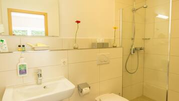 Ein modernes Badezimmer mit Waschbecken, Toilette und einer Duschkabine.
