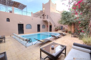 Alberca al aire libre y camastros 