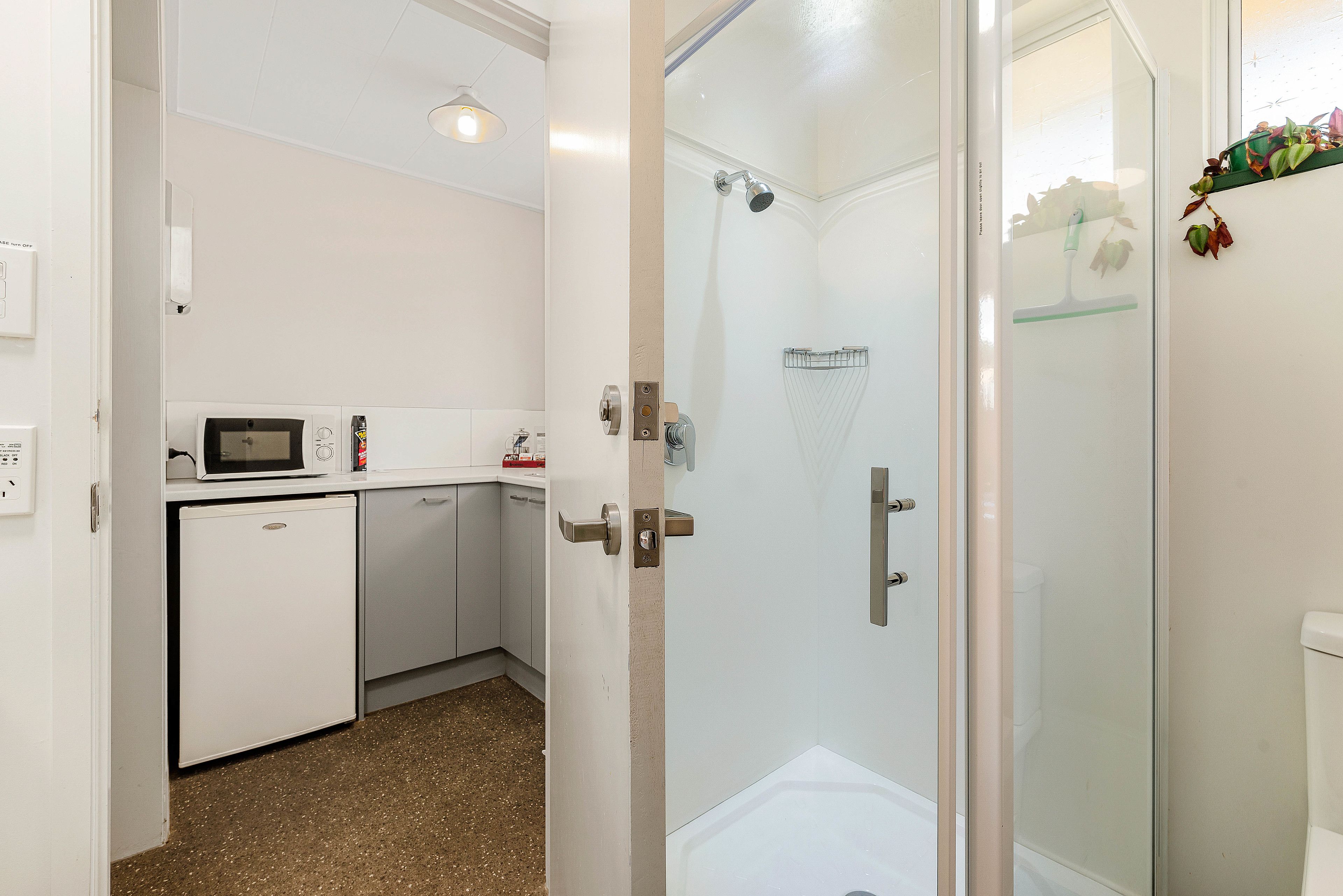 A compact kitchen with a microwave, refrigerator, and sink.