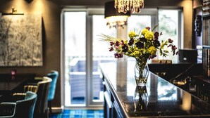 A bar area with a vase of flowers, chairs, and a view of the outdoors. - Tir-y-Coed Country House (Conwy)