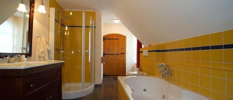 A bathroom with a walk-in shower, a bathtub, and a wooden door.