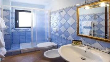 Un bagno con doccia, WC e lavandino.
