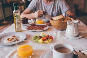 A breakfast table with plates of food, a jug of milk, and a bottle of orange juice. - Molino la Nava (Montoro)