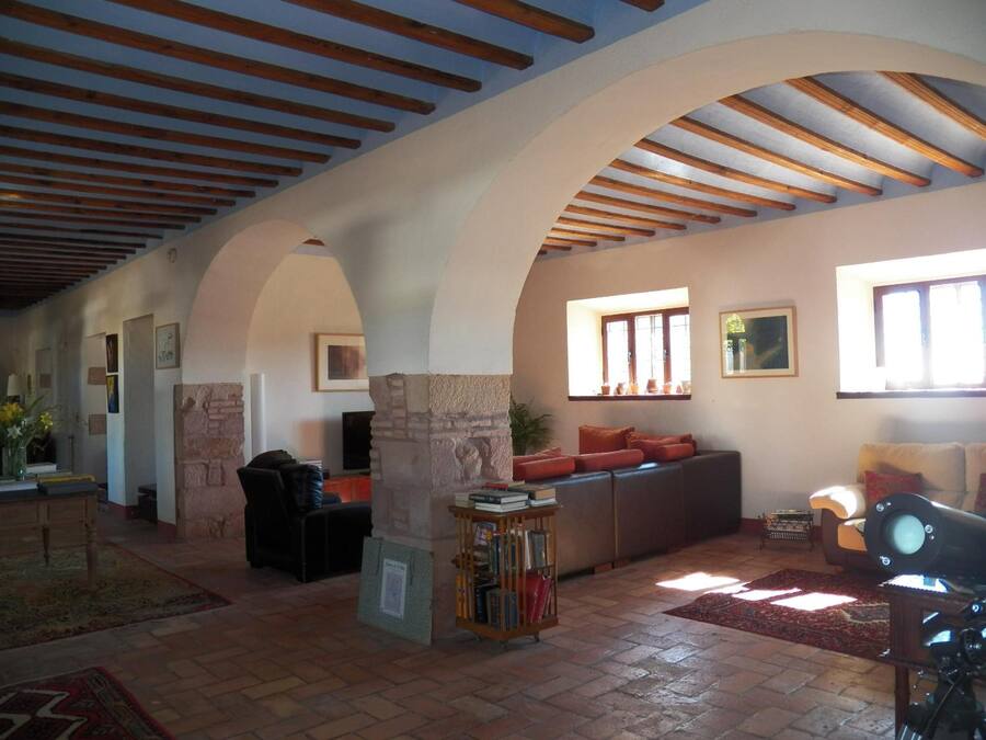 A spacious living area with a stone fireplace, a bookshelf, and a comfortable seating area.