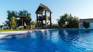 Una piscina al aire libre, camas de piscina gratis, sombrillas