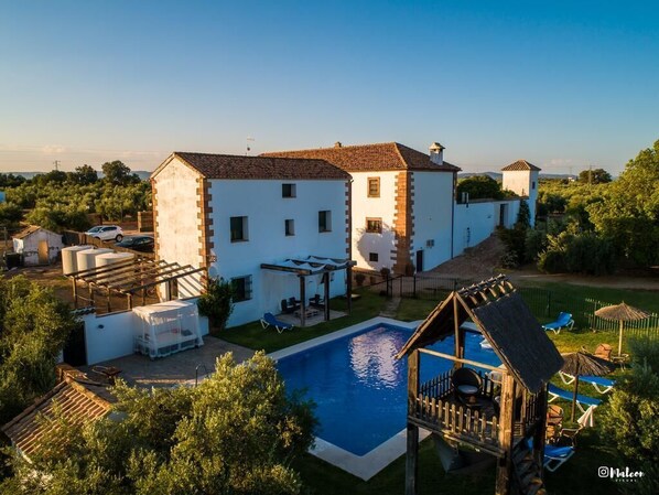 A large white building with a swimming pool, a wooden deck, and a small gazebo. - Molino la Nava (Montoro)