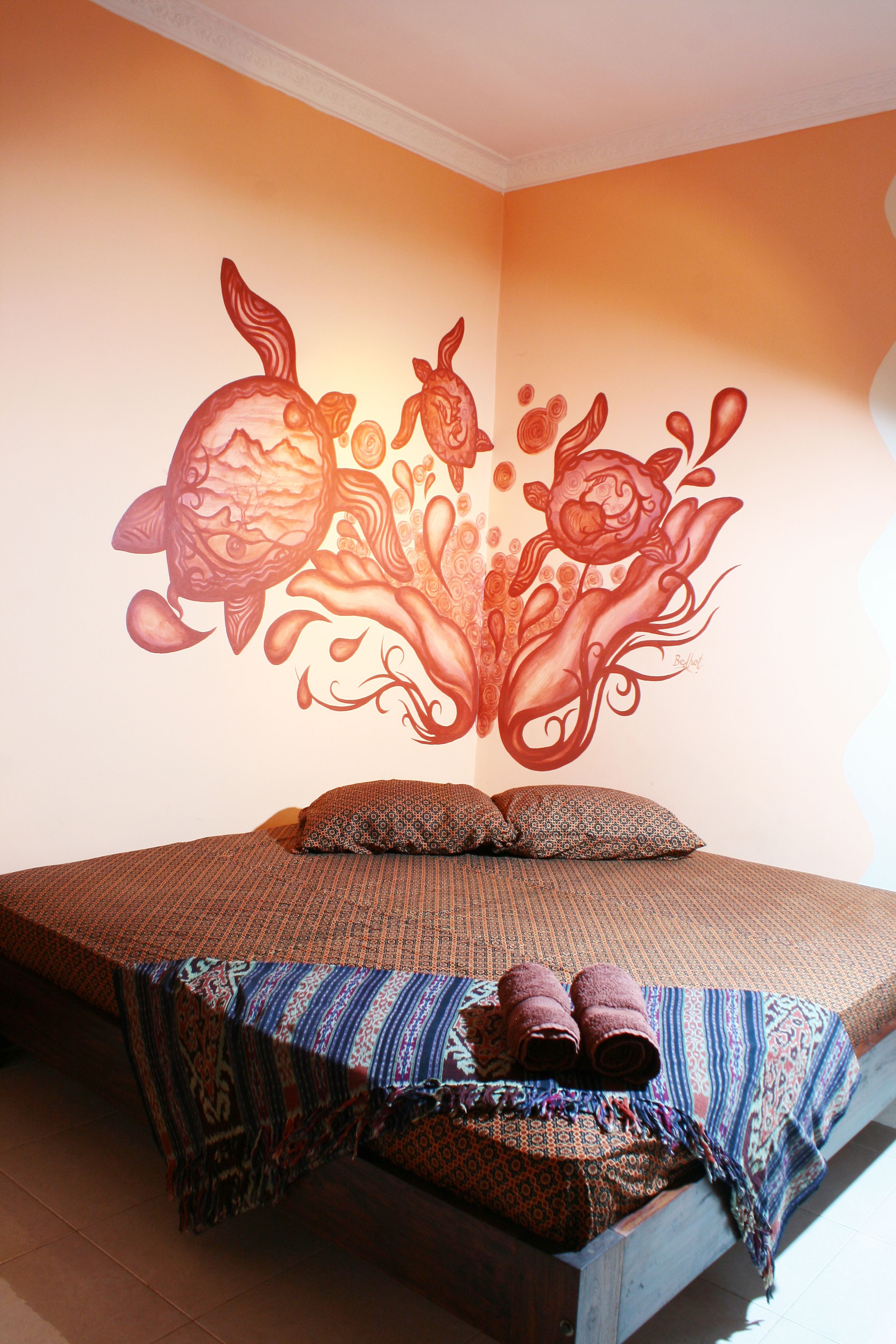 Un dormitorio con cama, almohadas y una colcha.