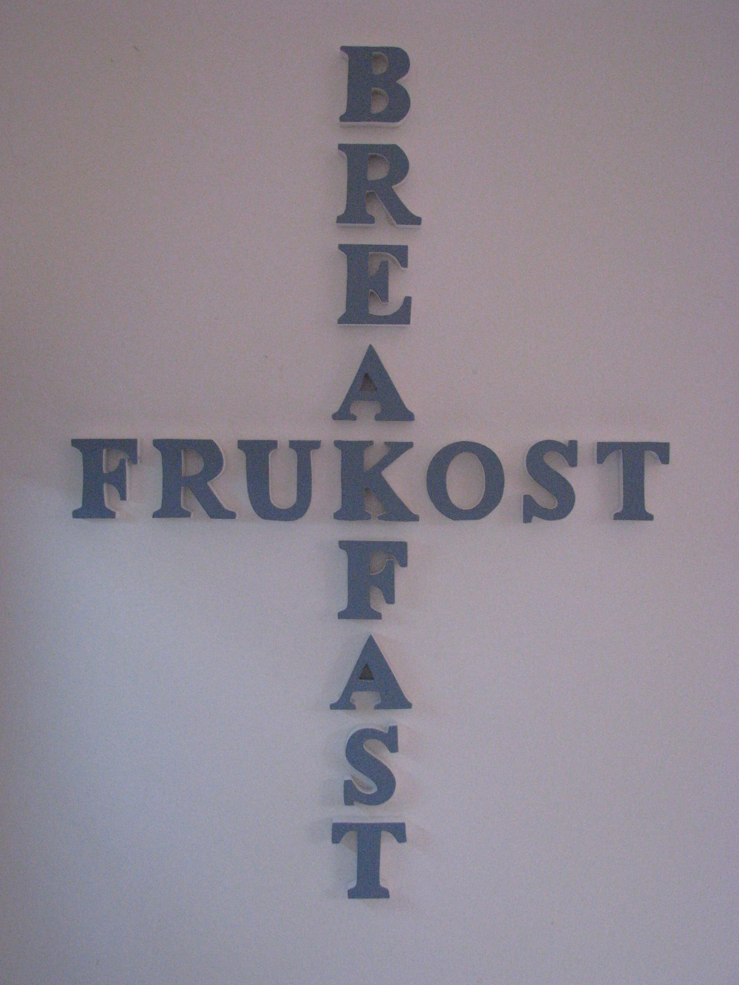 A wall with the words "BREAKFAST FRUKOST" arranged in a cross pattern.