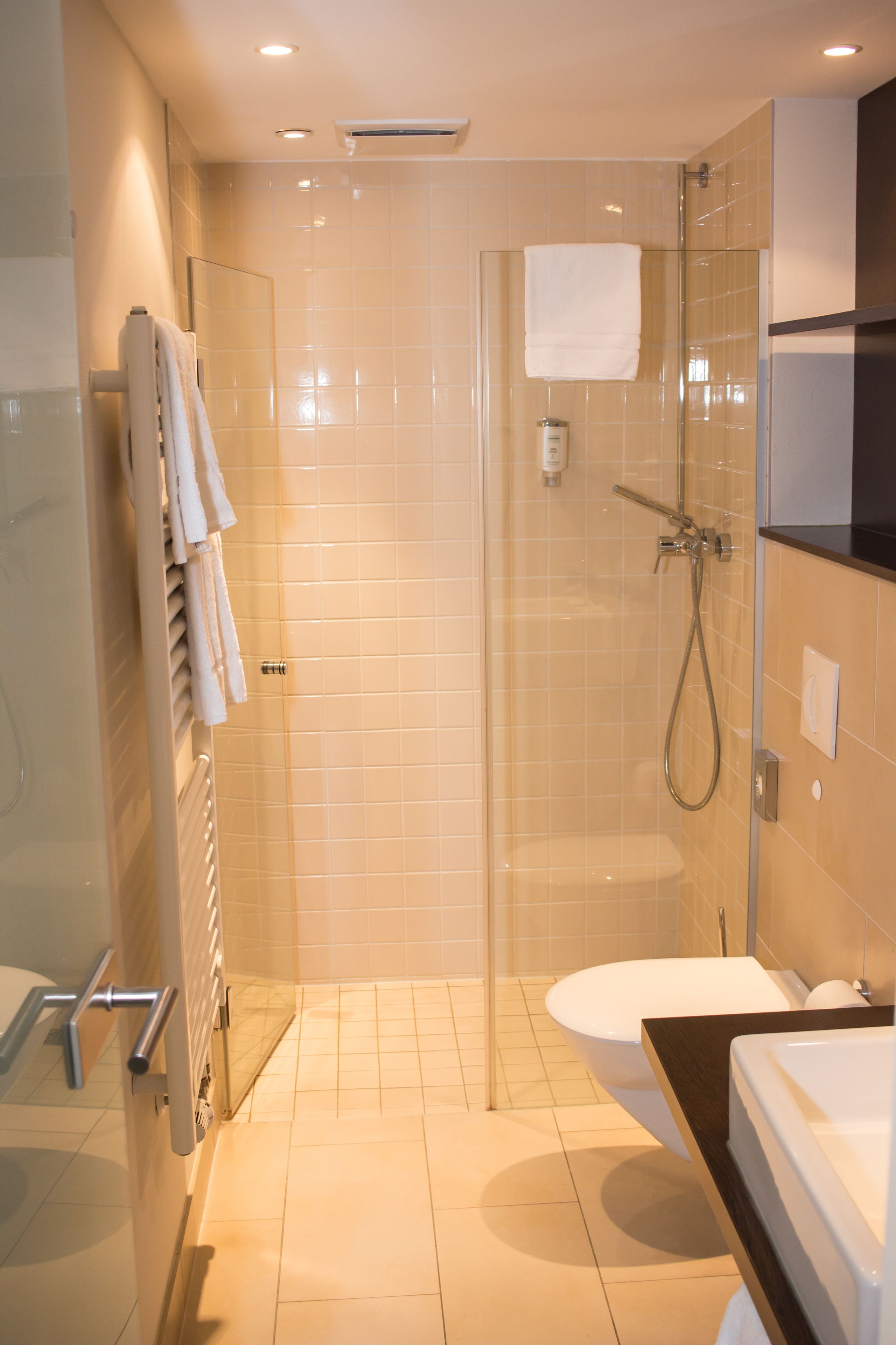 Ein modernes Badezimmer mit einer Glasdusche, einer Toilette und einer Badewanne.