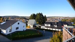 Una zona residencial con casas, cielo despejado y un paisaje montañoso al fondo.
