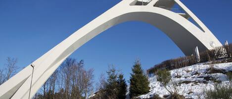 A large white arch structure with a clear sky in the background.