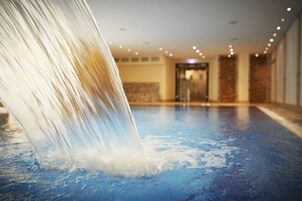 Una piscina techada, sillones reclinables de piscina