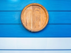 A round wooden object against a blue and white wall.