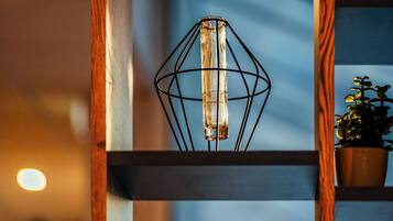 A modern interior with a geometric light fixture and a potted plant on a shelf.