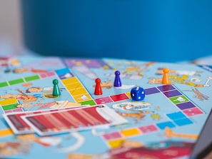 A board game with colorful pieces and cartoon characters on a blue board.