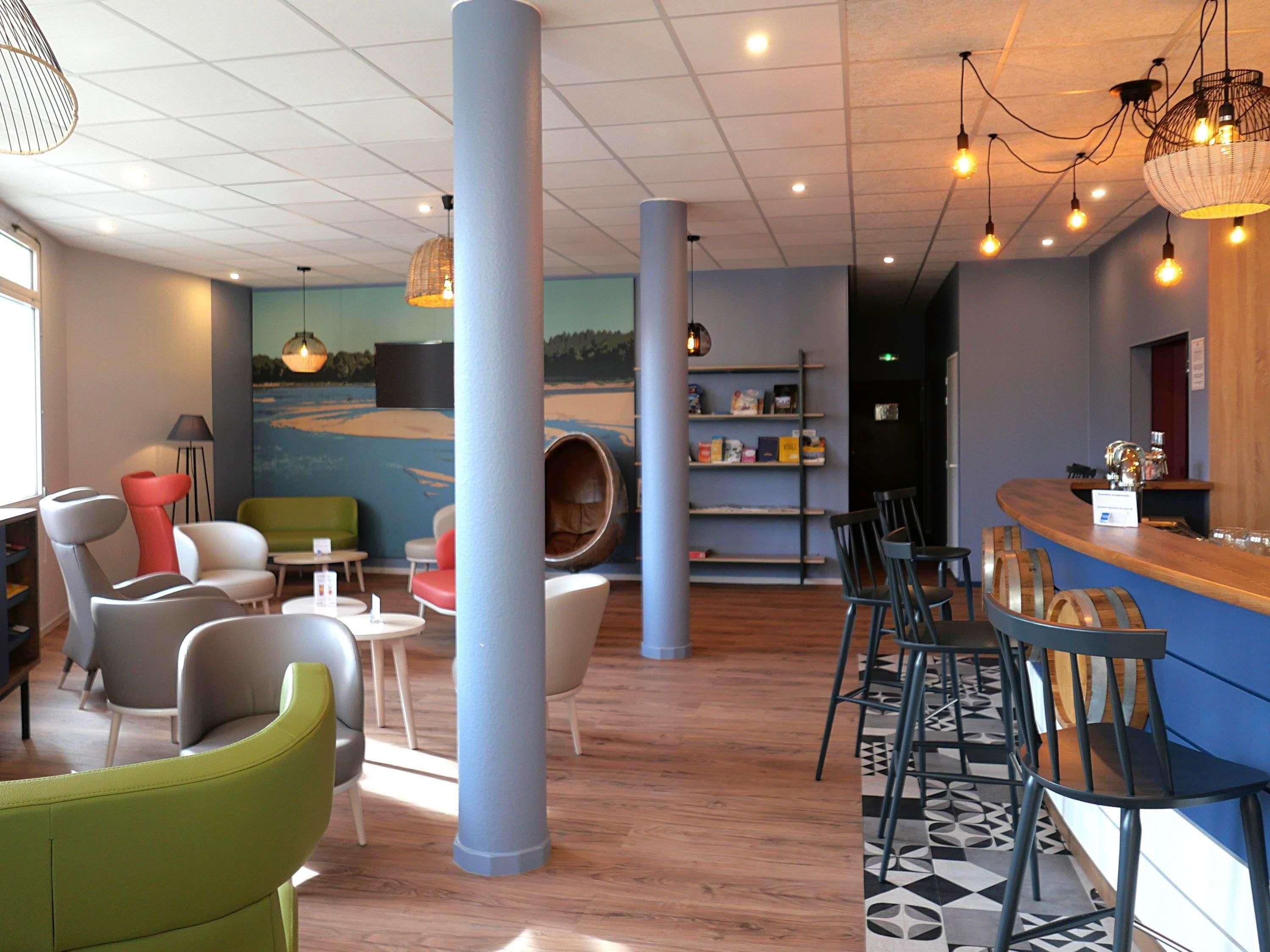 Un intérieur moderne avec des sièges, un coin bar et une fresque murale.