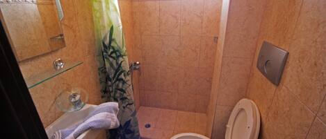 A bathroom with a shower, toilet, and sink.