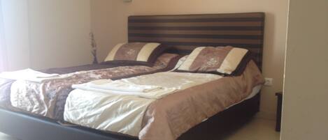 A bed with a wooden headboard, two pillows, and a blanket.