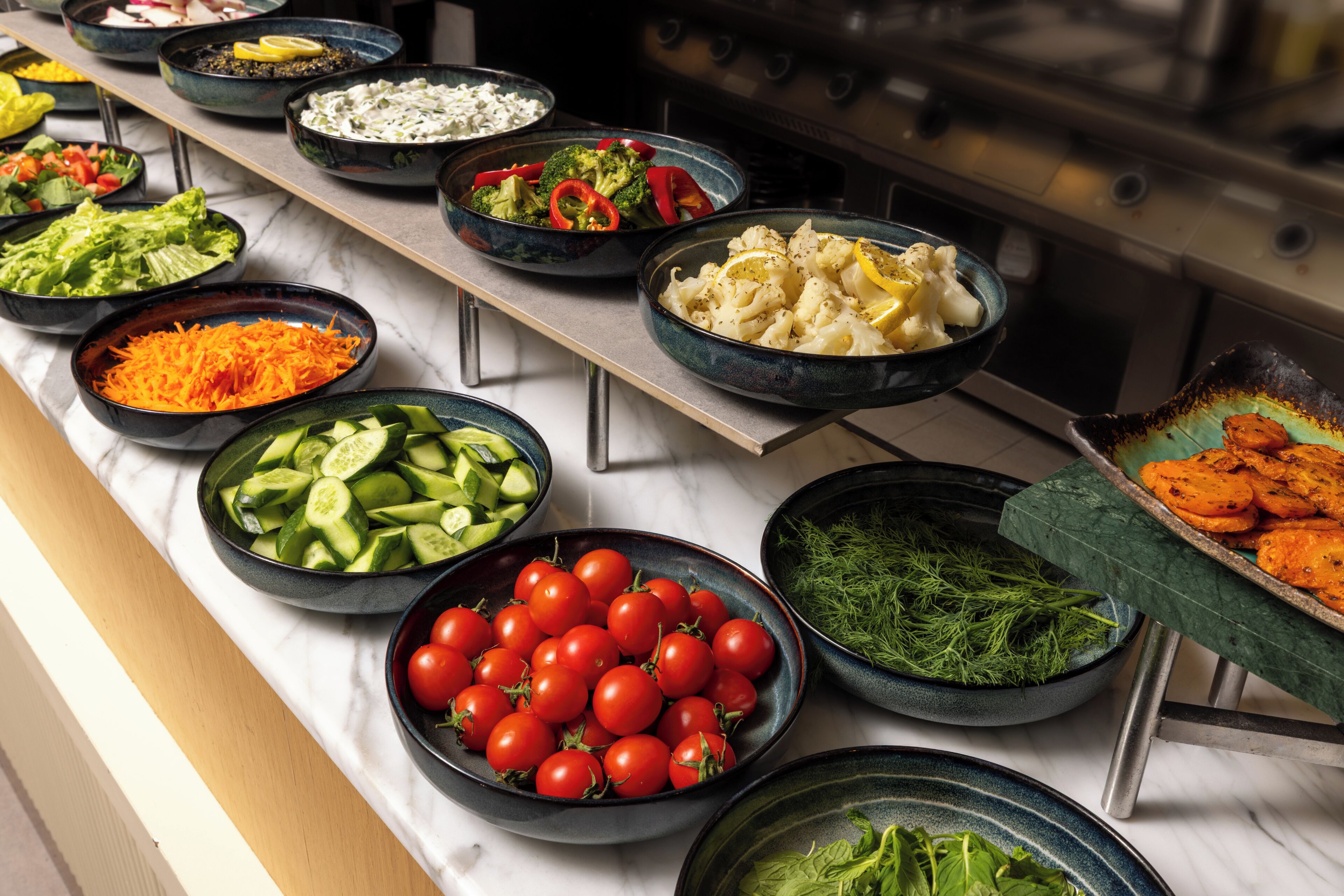 A buffet with various food items in bowls.