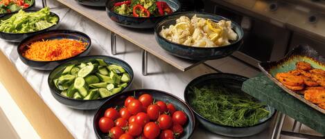 A buffet with various food items in bowls.