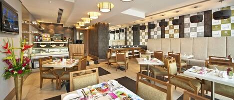 A modern restaurant with multiple dining areas, wooden furniture, and a variety of table settings.