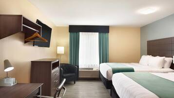 Una camera d'albergo con due letti, una scrivania con lampada, una sedia, un armadio e una finestra con tende.