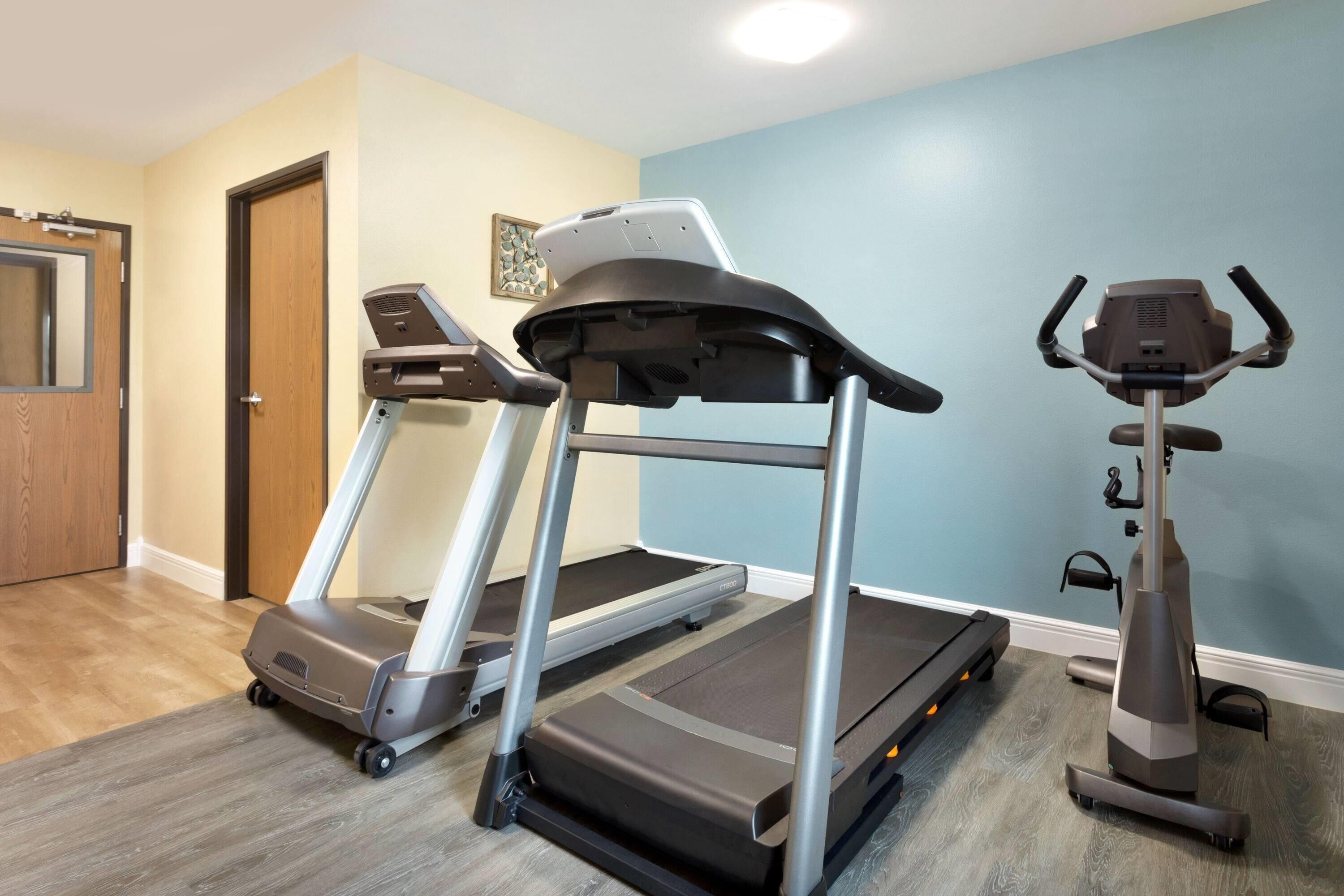Un gimnasio en casa con dos cintas de correr y una máquina elíptica.