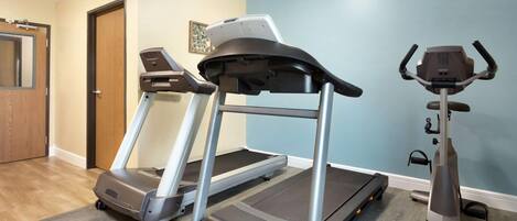 Un gimnasio en casa con dos cintas de correr y una máquina elíptica.