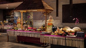 Montaje de bufé con un dosel decorativo, diversas opciones de comida y un área de asientos.