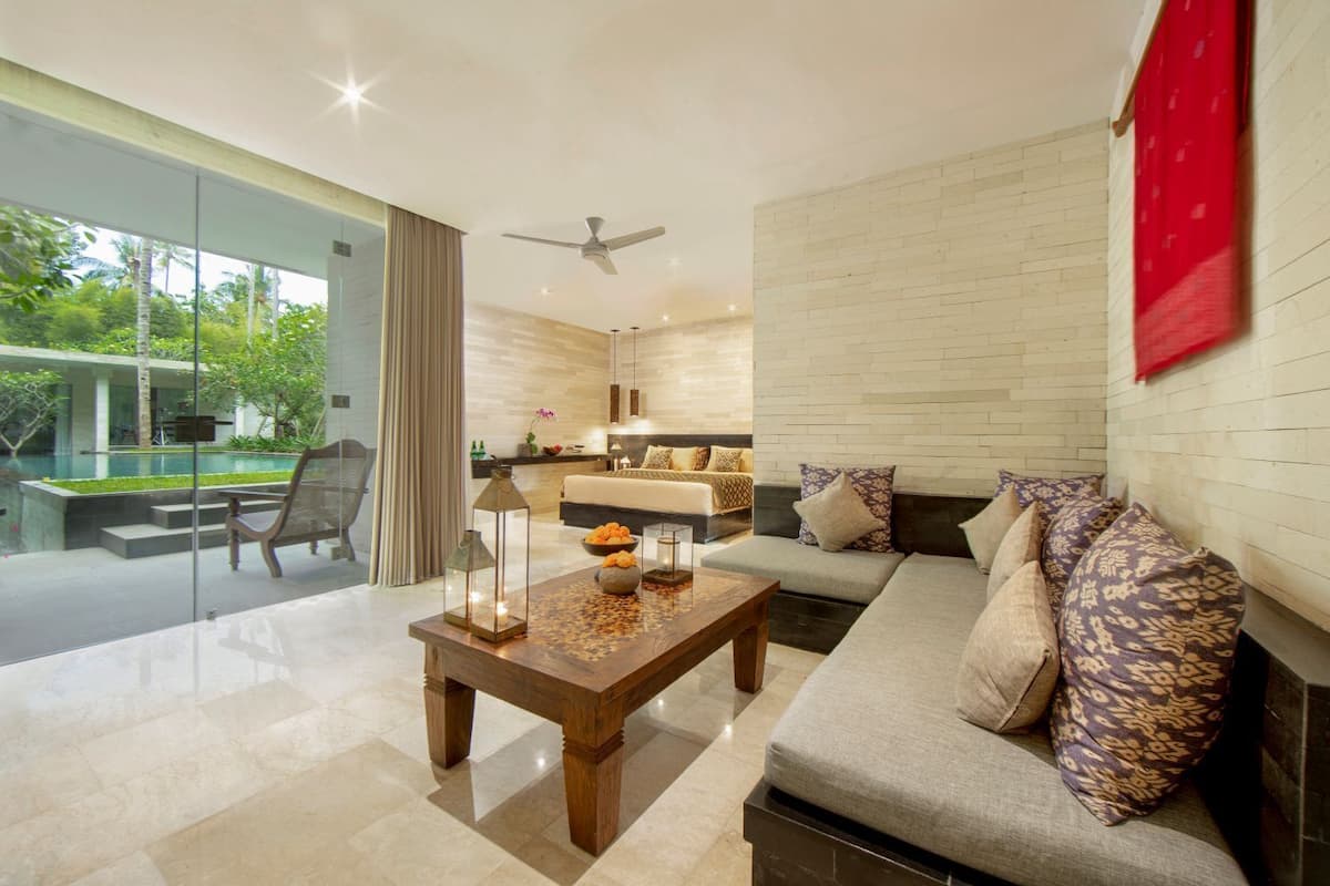 A modern living room with a sofa, a coffee table, and a dining area with a table and chairs.