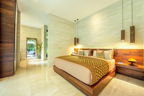 Une chambre moderne avec un grand lit, une tête de lit en bois et un luminaire suspendu.