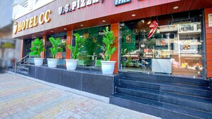 Un hotel con restaurante de pizza y pollo frito en la planta baja.