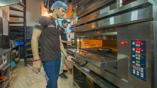 Una cocina con electrodomésticos de acero inoxidable, incluyendo un horno grande con panel de control digital.