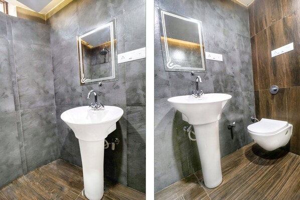 A bathroom with a white sink, a mirror, and a toilet. - Hotel City Castle (Amritsar)