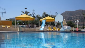 Een buitenzwembad, parasols voor strand/zwembad