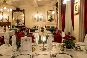 Formal dining area with elegantly set tables, fine china, and crystal glassware.