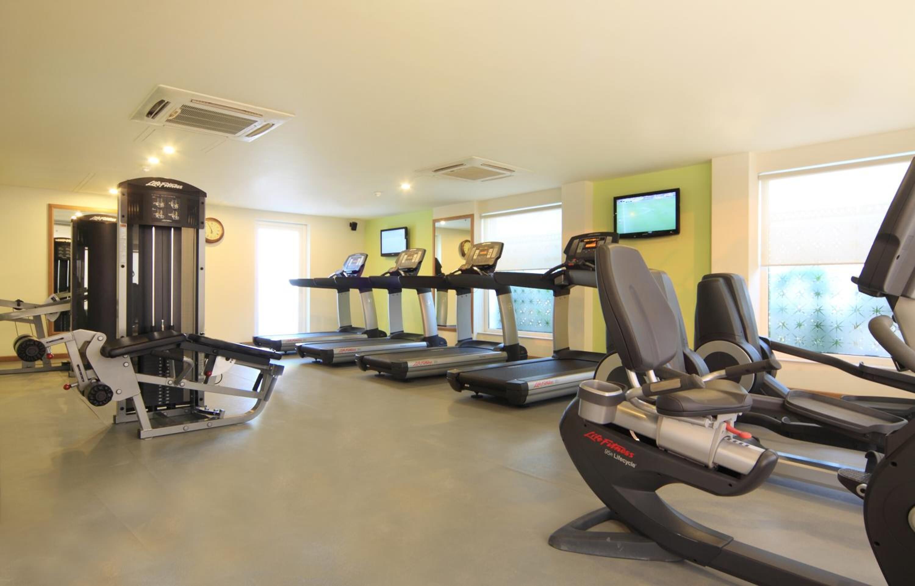 A gym with treadmills, elliptical machines, and a weight machine.